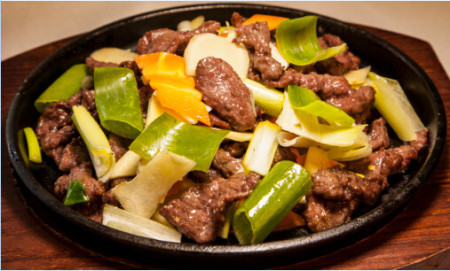 Ginger and onion venison stir fry on sizzling plate